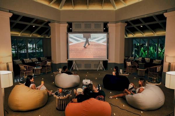 Gruppe von Gästen, die einen Film im Amatara Welleisure Resort Hotel im Kino-Loungebereich genießen