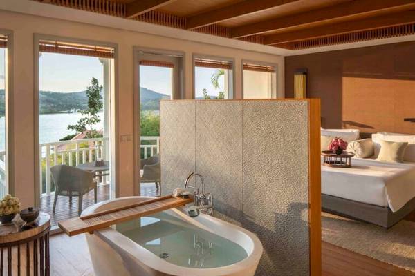 Zimmer im Amatara Welleisure Resort mit Badewanne und Blick auf den See.