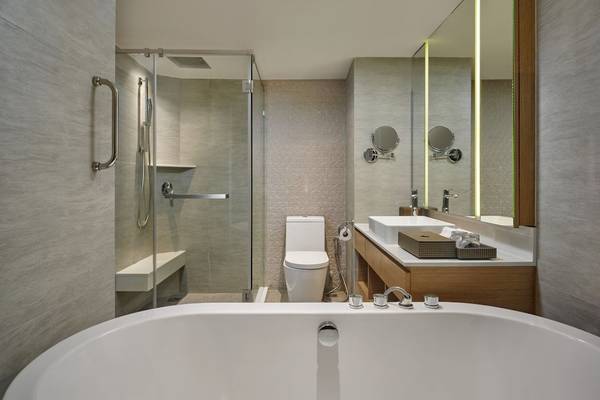 Badezimmer im Phuket Marriott Resort & Spa Merlin Beach mit Badewanne, Dusche und Waschbecken.