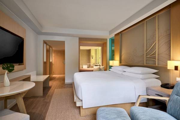 Schlafzimmer im Phuket Marriott Resort & Spa Merlin Beach mit großem Bett und modernen Möbeln.