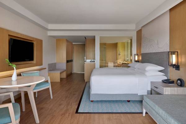 Schlafzimmer im Phuket Marriott Resort & Spa Merlin Beach mit Doppelbett, Fernseher und Tisch
