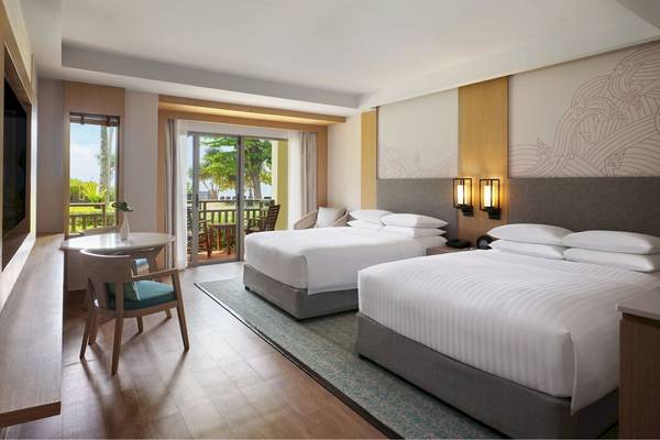Zweibettzimmer im Phuket Marriott Resort & Spa Merlin Beach mit Blick auf den Balkon und Garten.