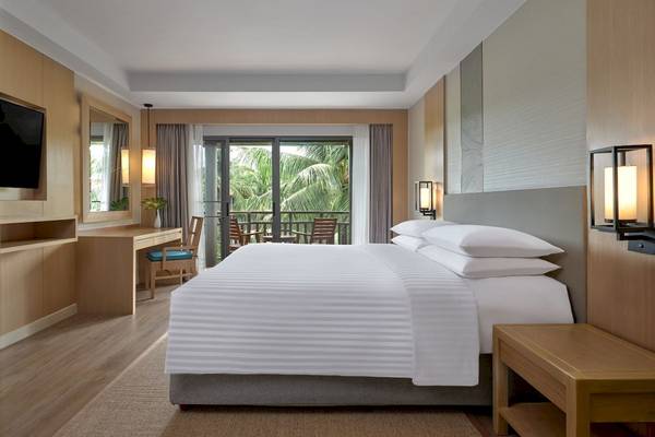 Hotelzimmer im Phuket Marriott Resort & Spa Merlin Beach mit einem großen Bett, Schreibtisch und Balkon.