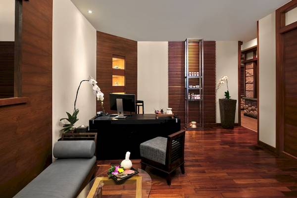 Innenansicht des Arbeitszimmers im Phuket Marriott Resort & Spa mit Schreibtisch, Pflanzen und gemütlichen Sitzmöbeln.