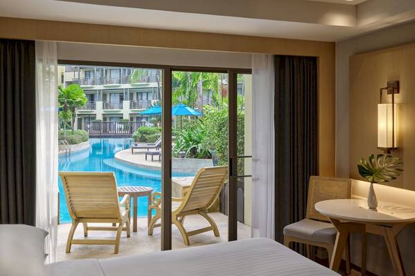 Zimmer im Phuket Marriott Resort mit Ausblick auf den Swimmingpool und Garten.