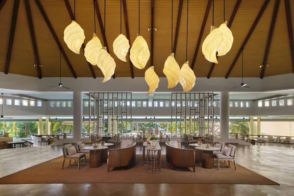 Innenansicht der Lobby des Phuket Marriott Resort & Spa Merlin Beach mit Sitzbereichen und Blatt-förmigen Lampen.