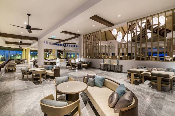 Loungebereich des Phuket Marriott Resort & Spa Merlin Beach mit Tischen, Stühlen und Sofas.