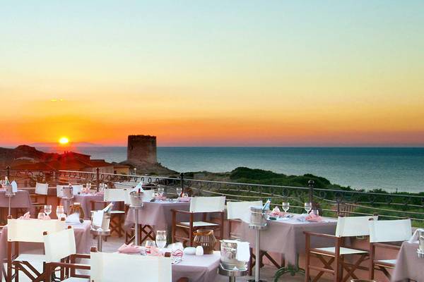 Terrasse mit Tischen und Stühlen beim Relax Torreruja Thalasso & Spa mit Blick auf den Sonnenuntergang am Meer.