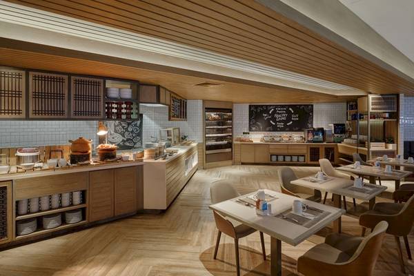 Frühstücksbereich im Phuket Marriott Resort & Spa Merlin Beach mit Buffet, Tischen und Stühlen.
