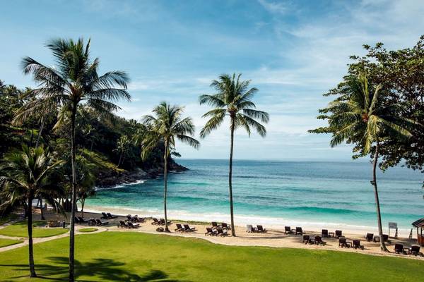 Strandausblick des Phuket Marriott Resort & Spa Merlin Beach mit Palmen und Sonnenliegen.