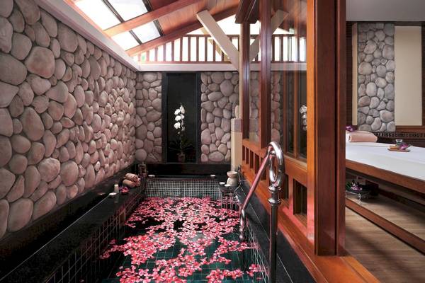 Innenbereich des Phuket Marriott Resort & Spa Merlin Beach mit Jacuzzi gefüllt mit roten Blütenblättern.