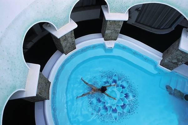 Luftaufnahme des Innenpools im Relax Torreruja Thalasso & Spa mit einer Person, die in einem Blumenmuster schwimmt.