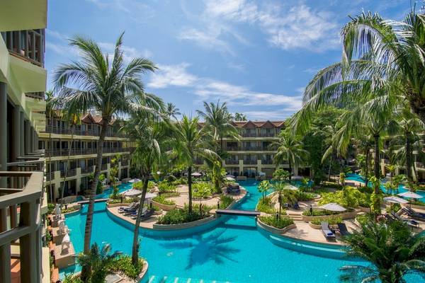 Außenansicht des Phuket Marriott Resort & Spa Merlin Beach mit Swimmingpool, Palmen und Sonnenliegen.