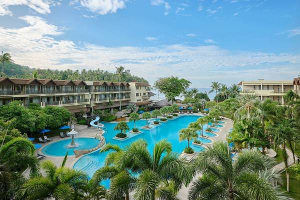 Außenansicht des Phuket Marriott Resort & Spa Merlin Beach mit Swimmingpool und Sonnenschirmen.