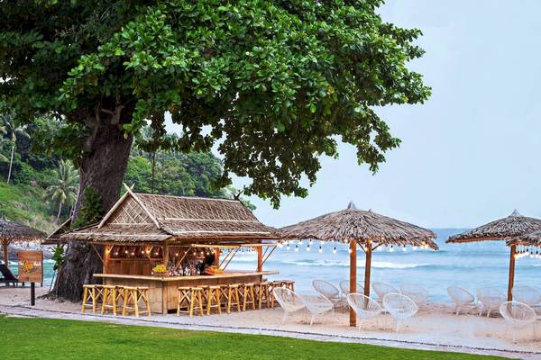 Strandbar des Phuket Marriott Resort & Spa am Merlin Beach mit Strohdächern und Stühlen