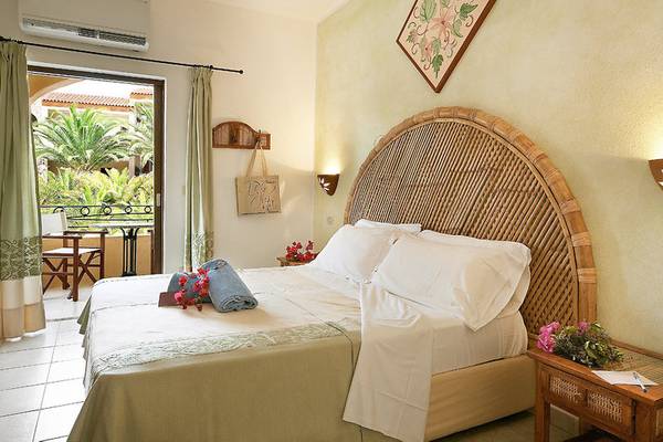 Schlafzimmer mit Balkon und Blick auf Palmen im Relax Torreruja Thalasso & Spa Hotel.