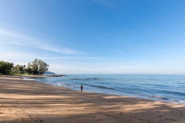Strand des X10 Khaolak Resorts mit blauem Himmel und einer Person am Ufer