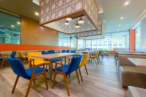 Innenbereich des X10 Khaolak Resorts mit blauen und gelben Stühlen und Tischen, modernes Design, Holzboden.