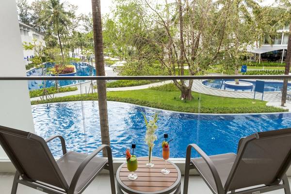 Terrasse des X10 Khaolak Resorts mit zwei Sesseln und Getränkegläsern vor einem Swimmingpool