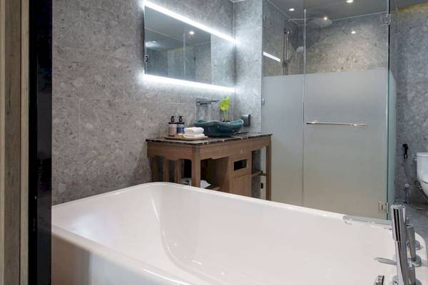 Ein Badezimmer im La Flora Khao Lak Hotel mit Badewanne, Waschtisch, Dusche und Toilette.