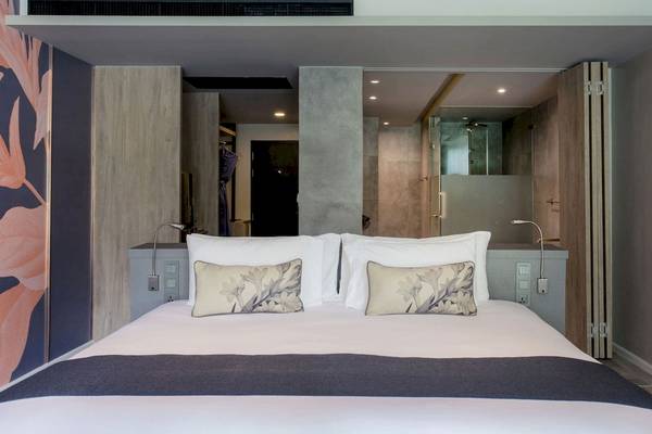 Schlafzimmer im La Flora Khao Lak Hotel mit großem Bett und modernen Möbeln.