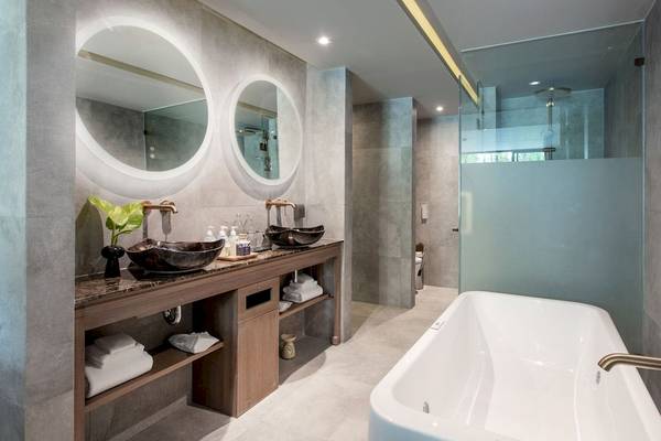 Ein modernes Badezimmer von La Flora Khao Lak mit zwei Waschbecken und einer Badewanne.