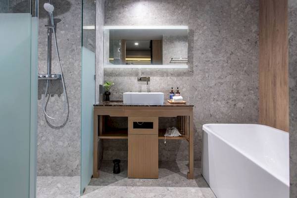 Badezimmer im La Flora Khao Lak Hotel mit Dusche, Waschbecken und Badewanne.