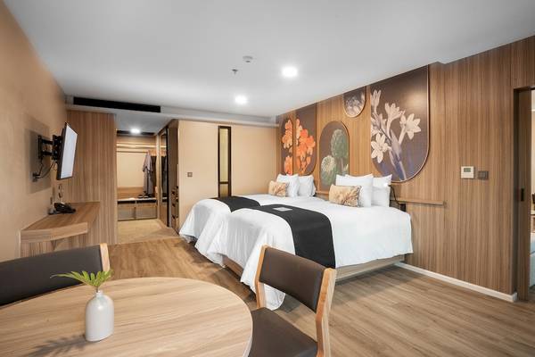 Innenansicht eines Hotelzimmers im La Flora Khao Lak mit zwei Betten und modernem Interieur.