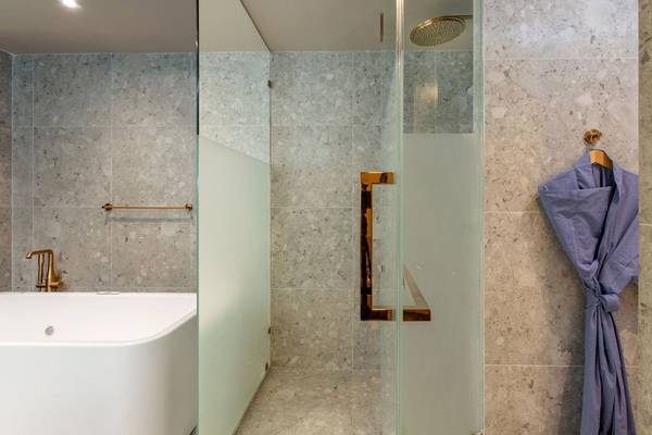Badezimmer im La Flora Khao Lak Hotel mit Badewanne und Glasdusche.
