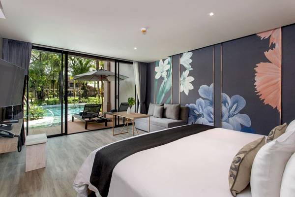 Luxuriöses Zimmer im La Flora Khao Lak Hotel mit Blick auf den Pool und blumige Wandgestaltung.