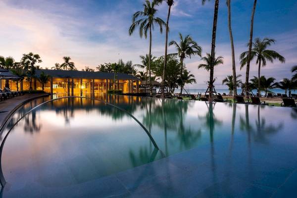 La Flora Khao Lak Hotel mit Swimmingpool und Palmen bei Sonnenuntergang