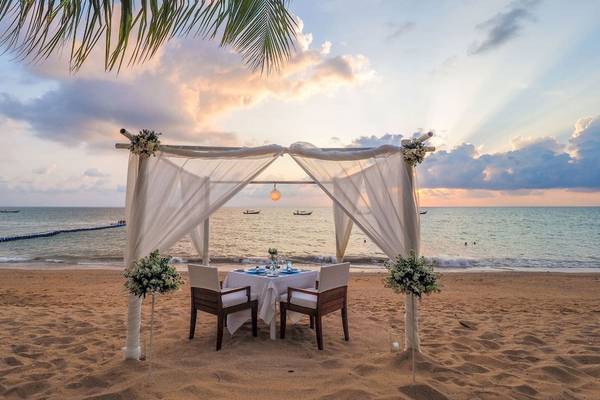 Tisch mit Blumendekoration auf dem Strand von La Flora Khao Lak