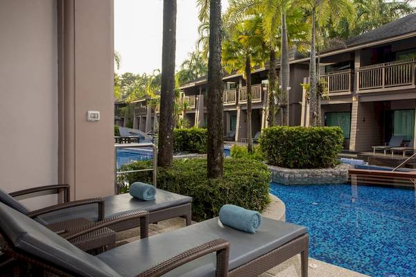 Pool- und Loungebereich des La Flora Khao Lak Hotels mit zwei Liegen und blauem Wasser.