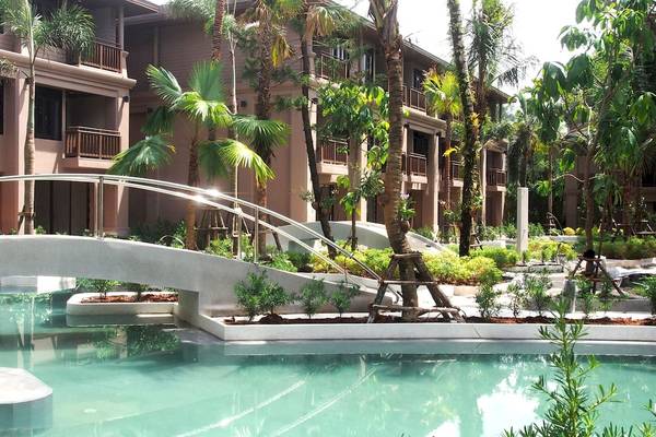 Ein Swimmingpool des La Flora Khao Lak Hotels mit einer Brücke davor.