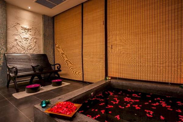 Wellnessbereich des La Flora Khao Lak Hotels mit einem großen Becken voller roter Rosenblätter.