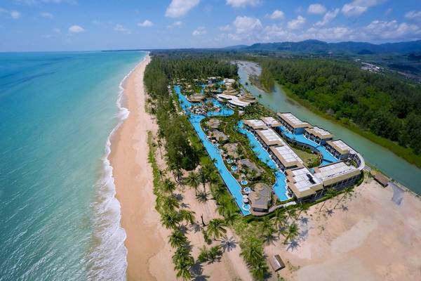 Luftaufnahme des The Haven Khao Lak Hotels am Strand mit Pools und Gebäuden.