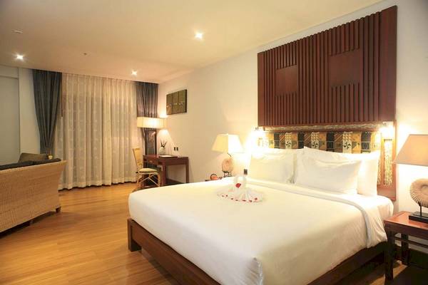 Hotelzimmer im The Haven Khao Lak mit einem großen Bett, Dekor und Möbeln.