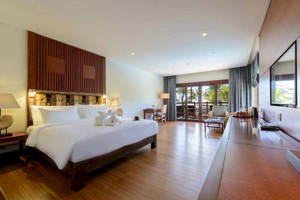 Innenansicht eines Zimmers im Haven Khao Lak mit großem Bett, Holzboden und Balkon