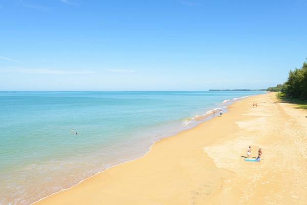 Aussicht auf den Strand von The Haven Khao Lak mit einigen Personen und blauem Wasser