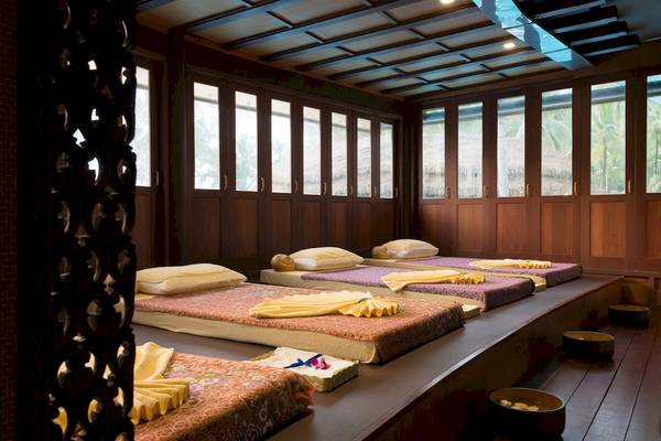 Massage-Behandlungsraum im Haven Khao Lak mit mehreren Betten und Fenstern.