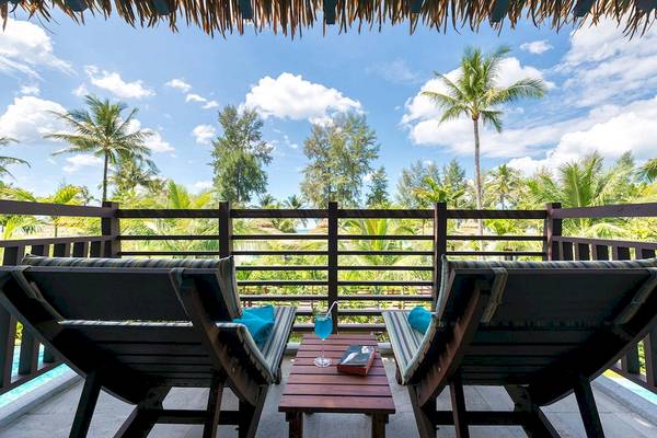 Zwei Sessel mit blauen Kissen auf einem Balkon mit Blick auf eine tropische Landschaft im Haven Khao Lak.