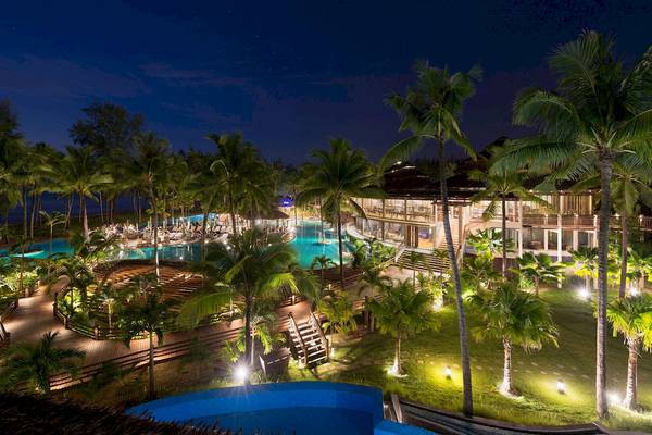 Abendliche Außenansicht des Haven Khao Lak Hotels mit beleuchtetem Pool, Terrassen und Palmen