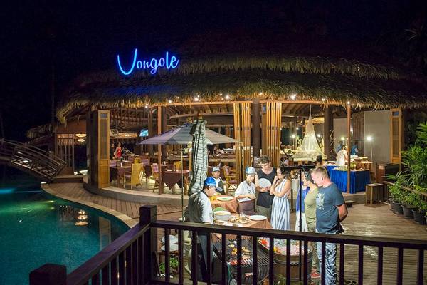 Gäste sitzen bei einem Abendessen draußen am Pool des The Haven Khao Lak.