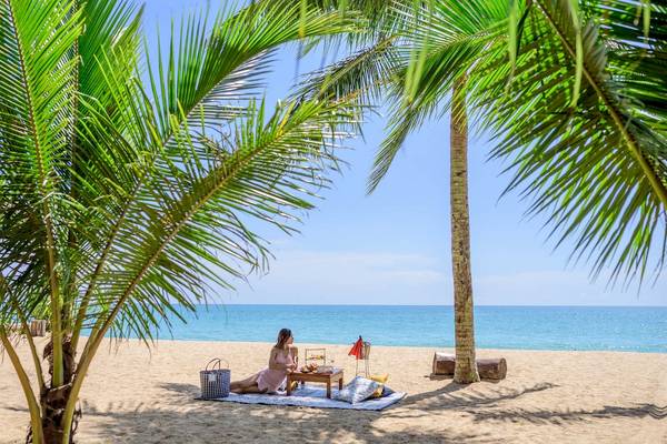 Frau auf dem Strand unter Palmen im Haven Khao Lak