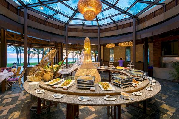 Buffetbereich im The Haven Khao Lak mit vielen Speisen und einer Person in Lila