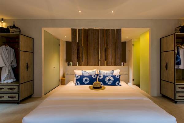 Schlafzimmer im Bangsak Village Hotel mit einem großen Bett und Holzelementen an der Wand.