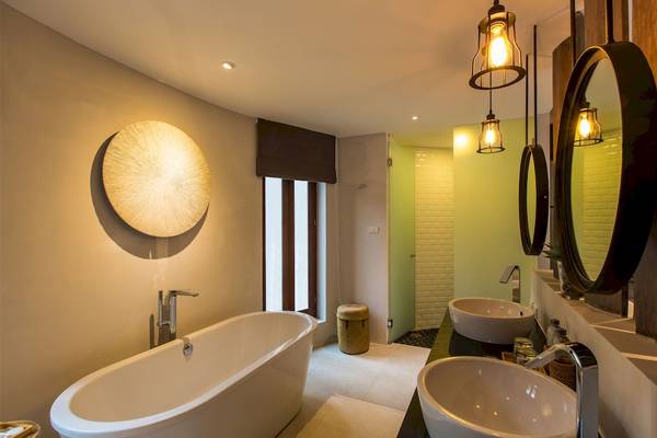 Badezimmer im Bangsak Village Hotel mit Badewanne, Waschbecken und Spiegeln.