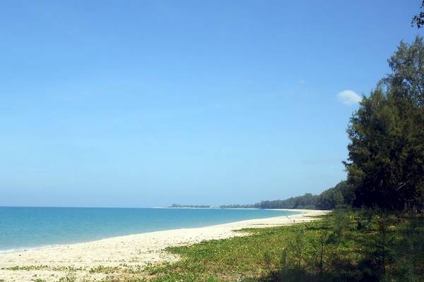 Foto einer weißen Strandlinie mit blauem Wasser und grüner Vegetation am Bangsak Village Hotel