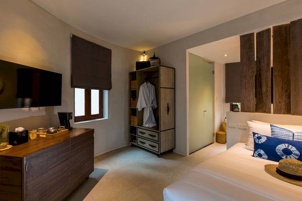 Ein Zimmer im Bangsak Village Hotel mit einem Bett, Fernseher, Kleiderschrank und Dekor.