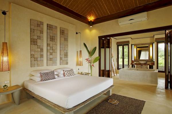 Schlafzimmer im Bangsak Village Hotel mit großem Bett, Wanddekorationen und offenem Badezimmer